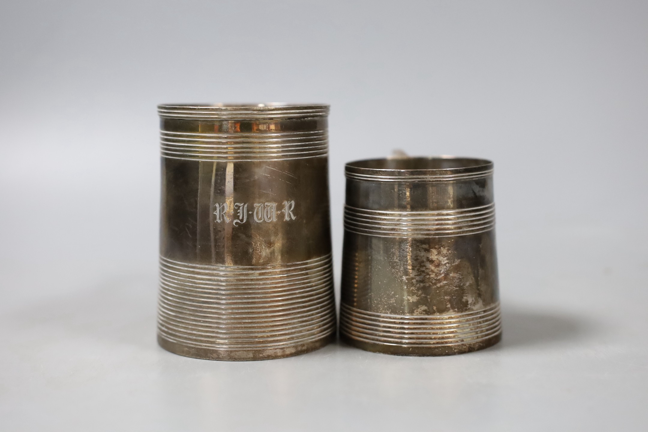 Two George III silver christening mugs, both with reeded bands, Thomas Meriton, London, 1801, 62mm and Charles Chesterman II, London, 1803, 83mm, the latter with later? engraved initials, 7.5oz.